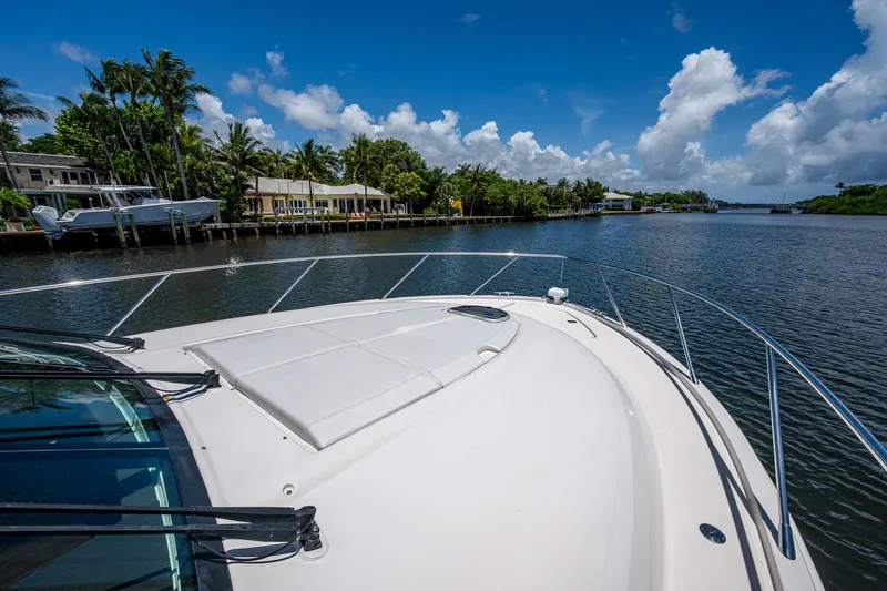 Hwyl Fawr Yacht Photos Pics 2018 Tiara Yachts F53 Flybridge cruising on a scenic waterway under a clear blue sky.