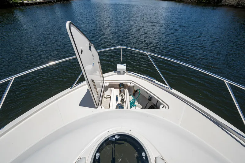 Hwyl Fawr Yacht Photos Pics 2018 Tiara Yachts F53 Flybridge bow with open hatch, overlooking serene water.