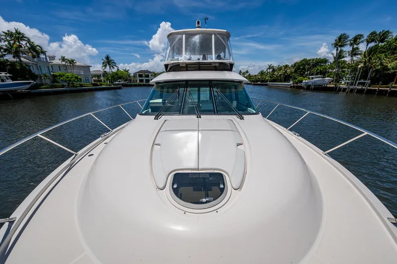 Hwyl Fawr Yacht Photos Pics 2018 Tiara Yachts F53 Flybridge on a sunny day, docked in a serene canal.