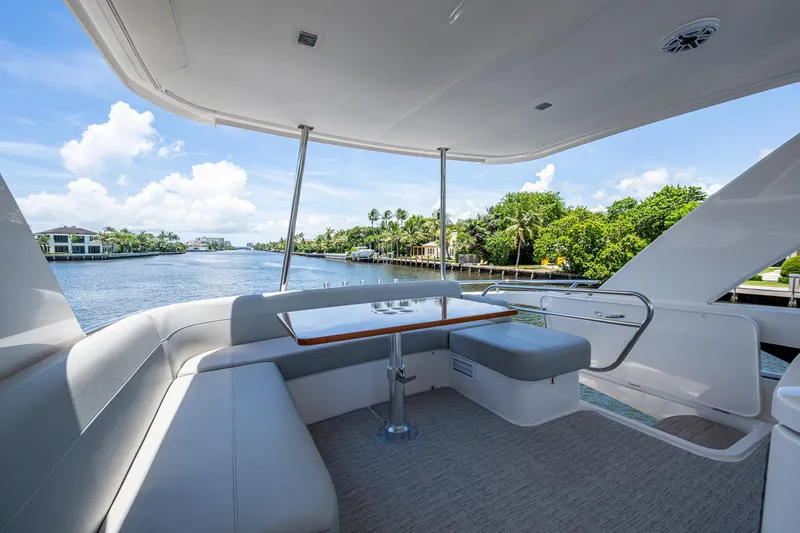 Hwyl Fawr Yacht Photos Pics 2018 Tiara Yachts F53 Flybridge with scenic waterway view and luxurious seating area.