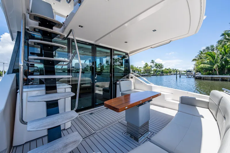 Hwyl Fawr Yacht Photos Pics 2018 Tiara Yachts F53 Flybridge, elegant deck with seating and table, overlooking serene waterway.