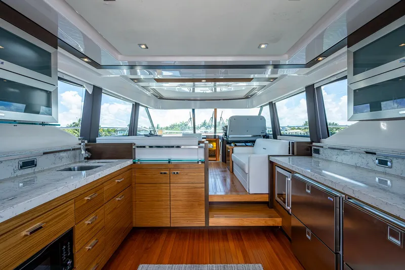 Hwyl Fawr Yacht Photos Pics Luxurious interior of 2018 Tiara Yachts F53 Flybridge with modern kitchen and panoramic windows.