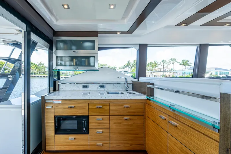 Hwyl Fawr Yacht Photos Pics Luxurious 2018 Tiara Yachts F53 Flybridge kitchen with modern wood cabinetry and sleek design.
