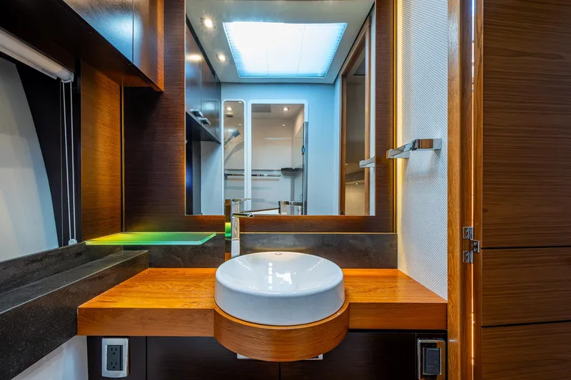 Hwyl Fawr Yacht Photos Pics Luxurious bathroom interior of 2018 Tiara Yachts F53 Flybridge with modern sink and wood accents.