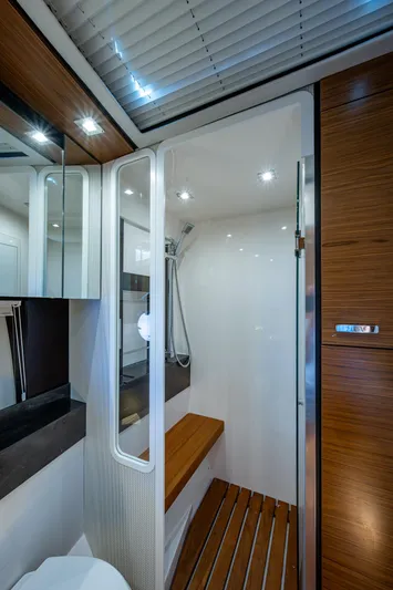Hwyl Fawr Yacht Photos Pics 2018 Tiara Yachts F53 Flybridge bathroom with modern shower and wooden accents.