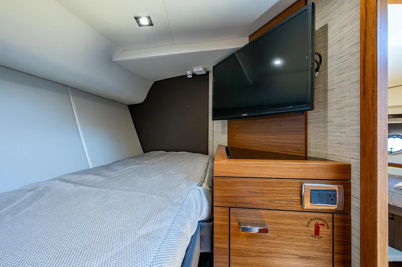 Hwyl Fawr Yacht Photos Pics 2018 Tiara Yachts F53 Flybridge cabin with bed, TV, and wooden cabinetry.