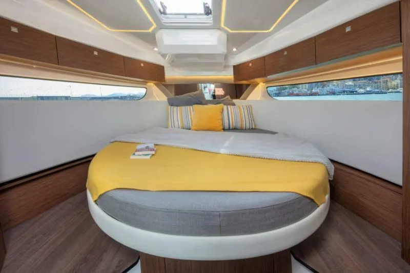  Yacht Photos Pics Luxurious cabin interior of 2025 Jeanneau NC 1095 Fly with modern design and cozy bedding.