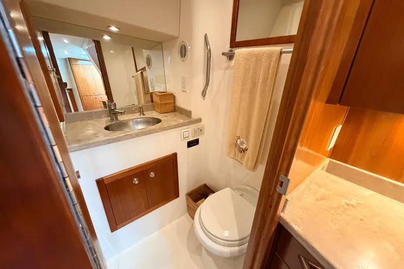 Moana Here Yacht Photos Pics Bathroom interior of 2015 Albemarle 360 Express Fisherman, featuring sink, toilet, and wooden cabinetry.