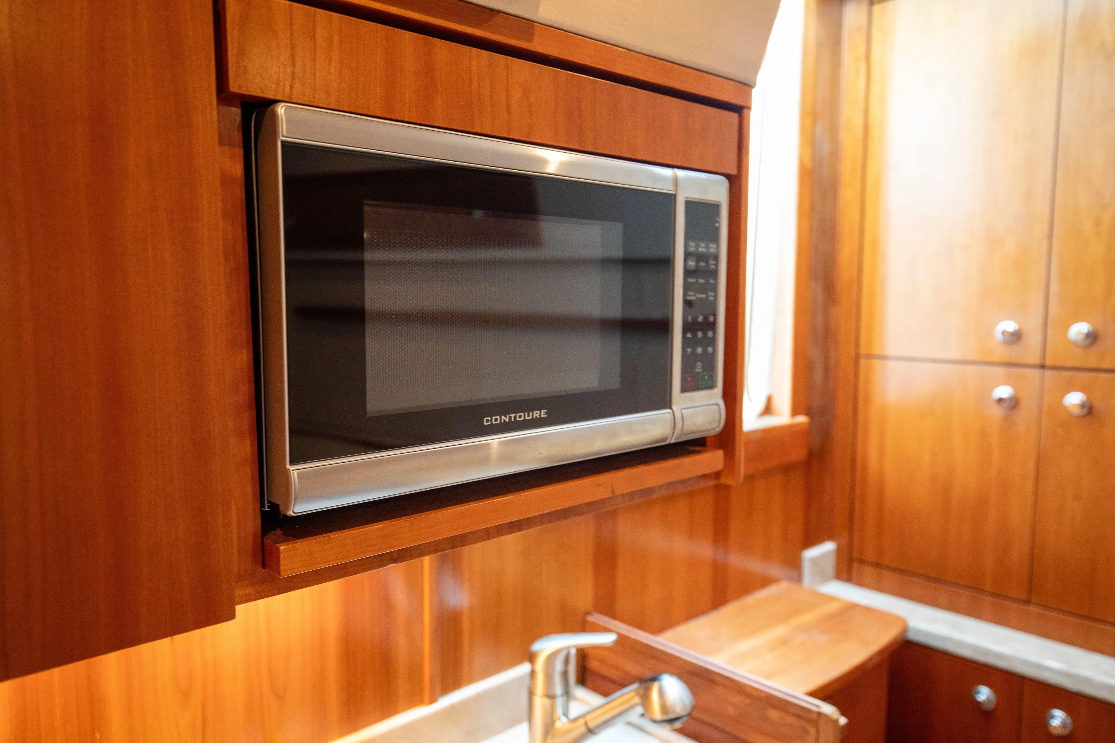 Moana Here Yacht Photos Pics Microwave in 2015 Albemarle 360 Express Fisherman yacht kitchen, featuring wooden cabinetry.