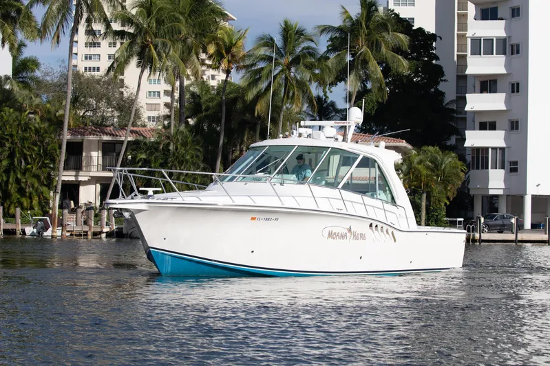 Moana Here Yacht Photos Pics 2015 Albemarle 360 Express Fisherman boat on water near palm trees and buildings.