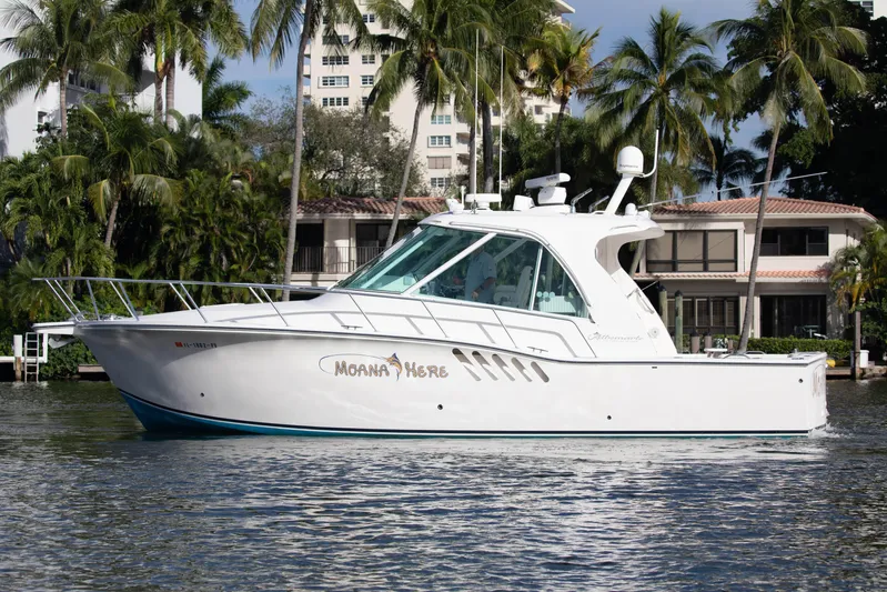 Moana Here Yacht Photos Pics 2015 Albemarle 360 Express Fisherman boat on water, surrounded by palm trees and buildings.