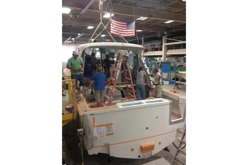 Moana Here Yacht Photos Pics Workers assembling a 2015 Albemarle 360 Express Fisherman boat in a factory setting.