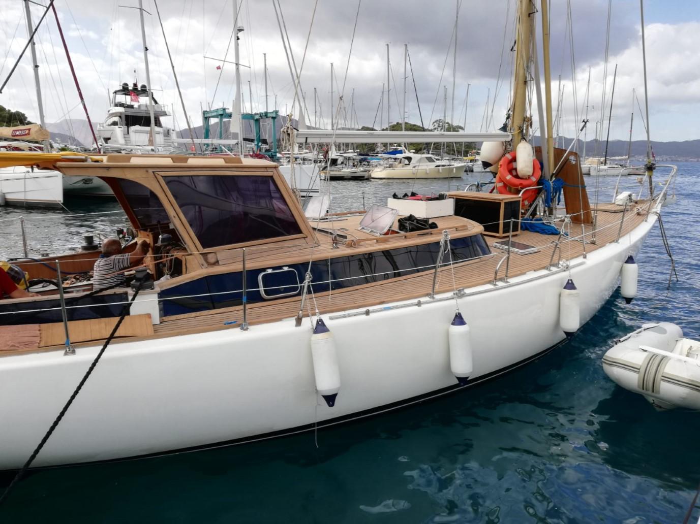 1973 Sloop Beaufort 14 Bluewater Cruiser docked in marina, featuring wooden deck and white hull.
