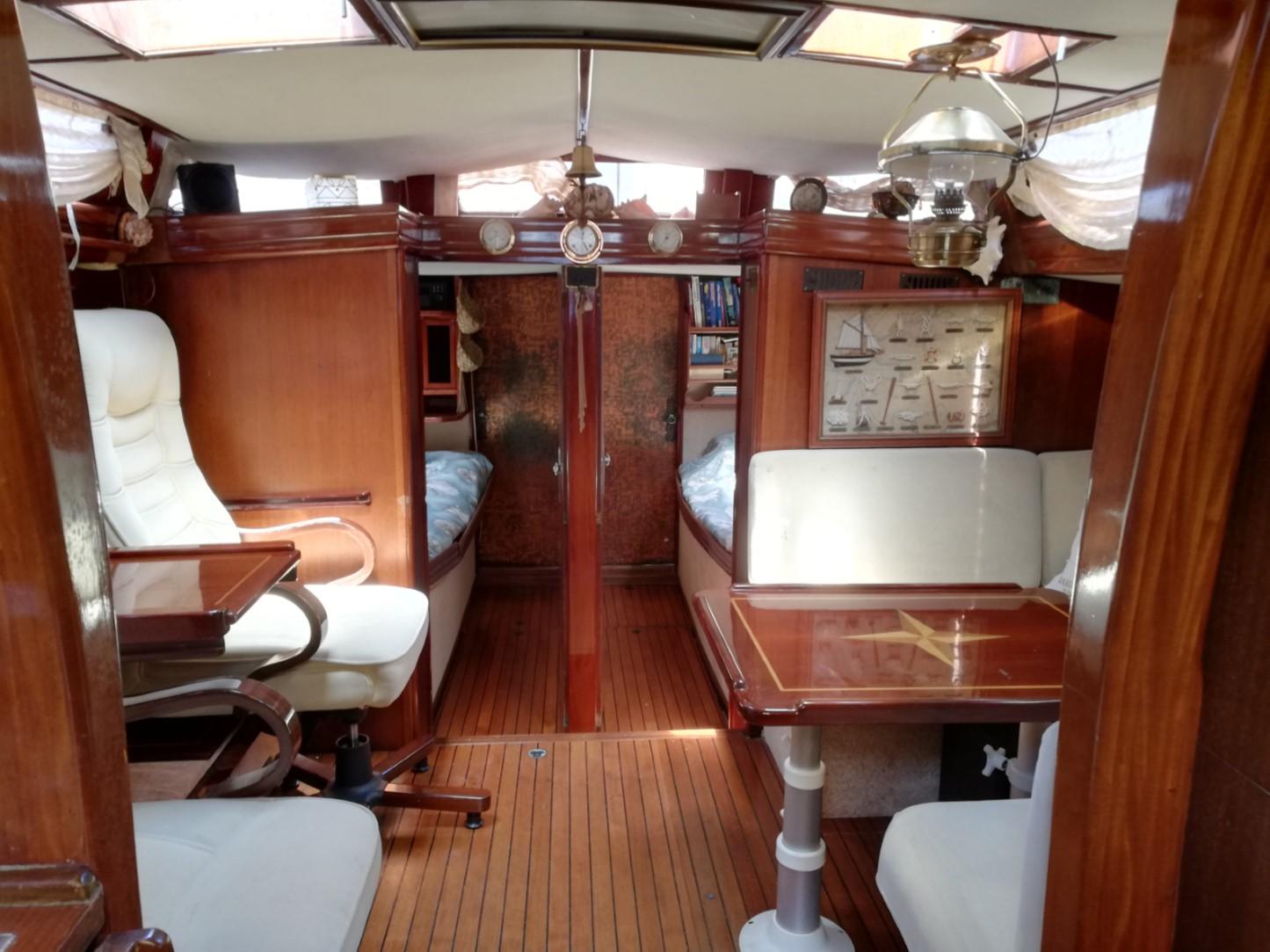 Interior of 1973 Sloop Beaufort 14 Bluewater Cruiser with wooden furnishings and cozy seating.