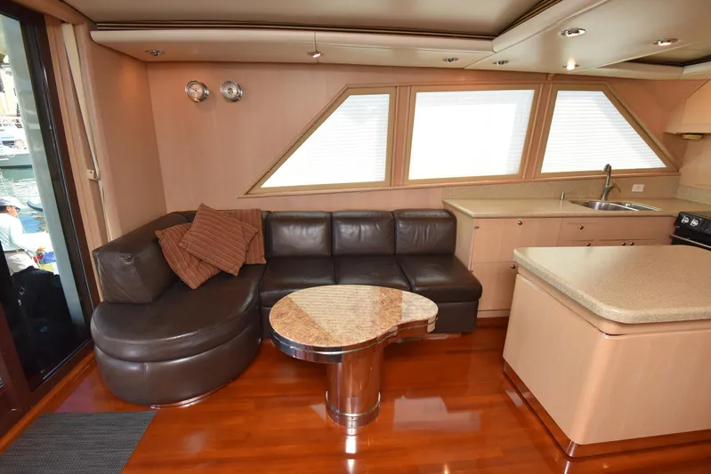 Talisman Yacht Photos Pics Interior of a 1989 Striker 62 Convertible yacht with leather sofa and kitchen.