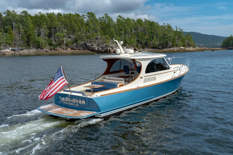 The Do-over Yacht Photos Pics 2024 Hinckley Picnic Boat 40 cruising on a scenic lake with lush green shoreline.