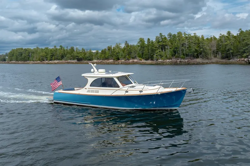 The Do-over Yacht Photos Pics 2024 Hinckley Picnic Boat 40 cruising on a lake with forested shoreline.