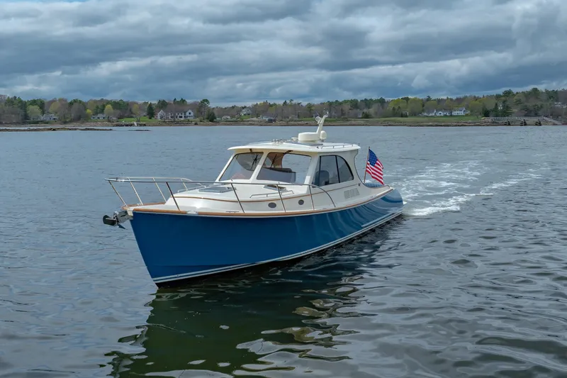 The Do-over Yacht Photos Pics 2024 Hinckley Picnic Boat 40 cruising on a calm lake under cloudy skies.
