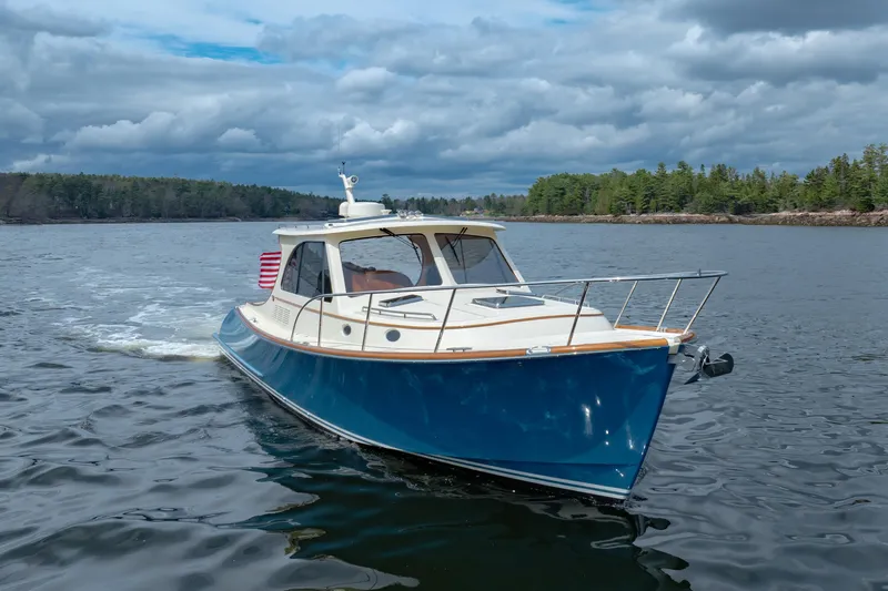The Do-over Yacht Photos Pics 2024 Hinckley Picnic Boat 40 cruising on a scenic lake under cloudy skies.