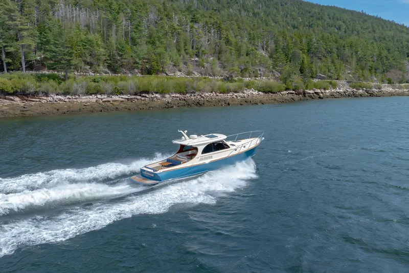 The Do-over Yacht Photos Pics 2024 Hinckley Picnic Boat 40 cruising on a scenic lake with forested shoreline.