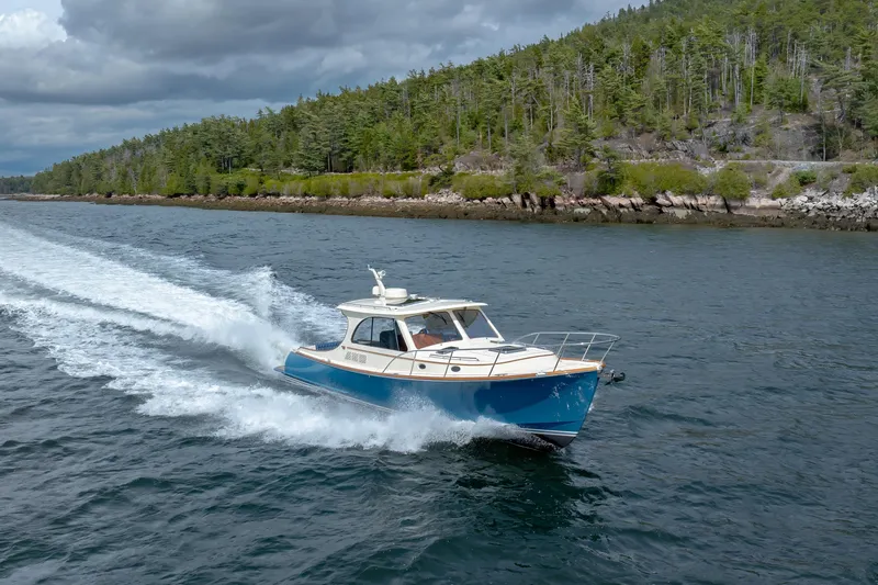 The Do-over Yacht Photos Pics 2024 Hinckley Picnic Boat 40 cruising on a scenic waterway with lush forest backdrop.
