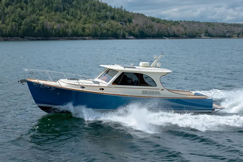 The Do-over Yacht Photos Pics 2024 Hinckley Picnic Boat 40 cruising on a scenic lake with forested shoreline.