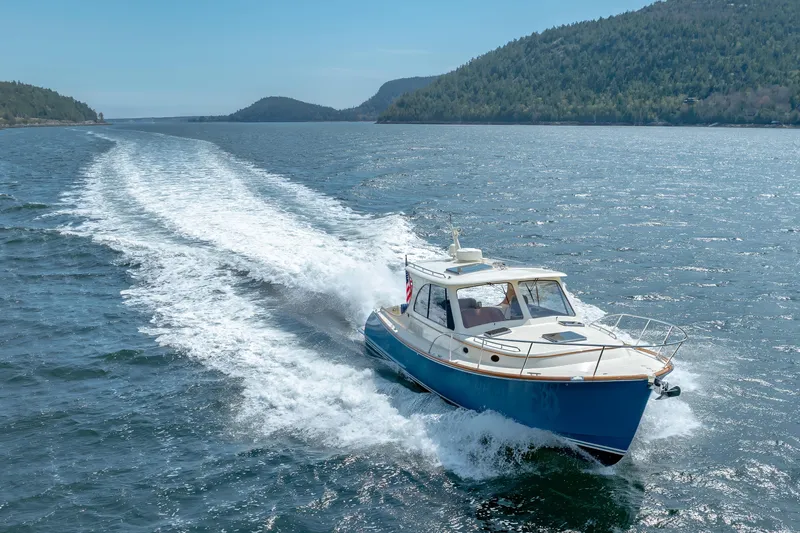 The Do-over Yacht Photos Pics 2024 Hinckley Picnic Boat 40 cruising on a scenic lake with forested hills.