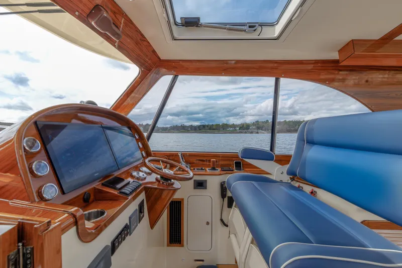 The Do-over Yacht Photos Pics 2024 Hinckley Picnic Boat 40 interior with blue seating and modern dashboard.