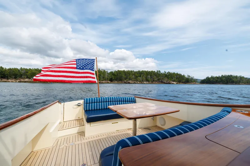 The Do-over Yacht Photos Pics 2024 Hinckley Picnic Boat 40 with American flag, cruising on a scenic lake.