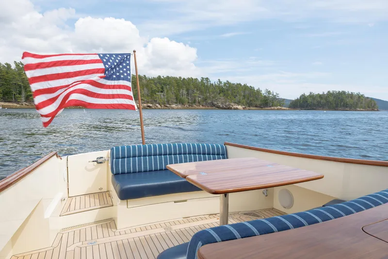 The Do-over Yacht Photos Pics 2024 Hinckley Picnic Boat 40 with American flag, scenic water view, and comfortable seating.