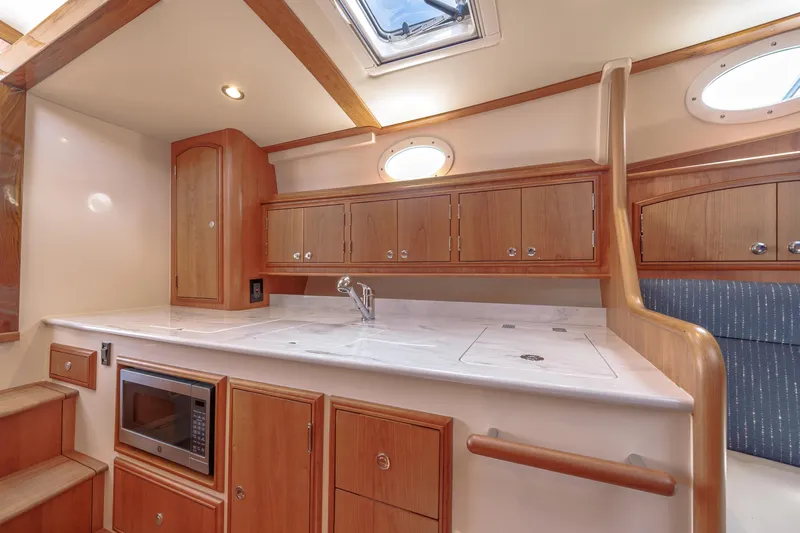 The Do-over Yacht Photos Pics 2024 Hinckley Picnic Boat 40 interior with wooden cabinetry and modern kitchen amenities.