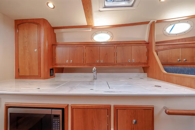 The Do-over Yacht Photos Pics 2024 Hinckley Picnic Boat 40 interior with wooden cabinetry and modern kitchen amenities.