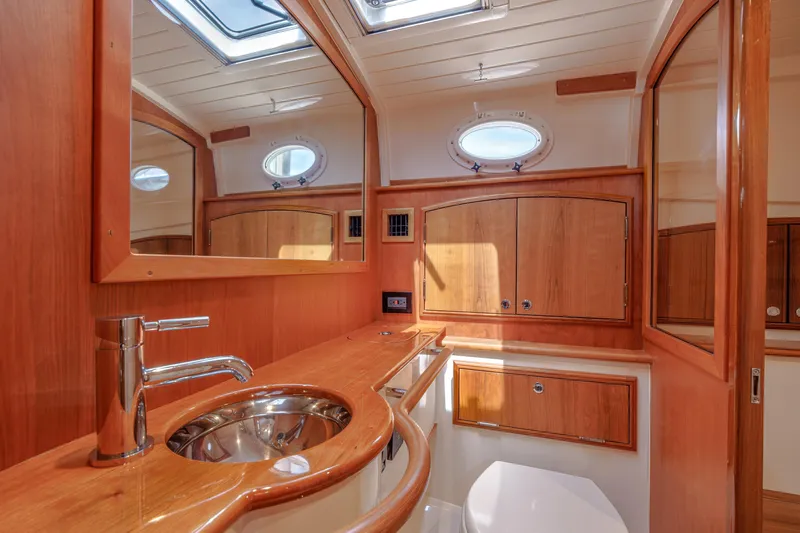 The Do-over Yacht Photos Pics Luxurious 2024 Hinckley Picnic Boat 40 bathroom with wood finish and modern fixtures.