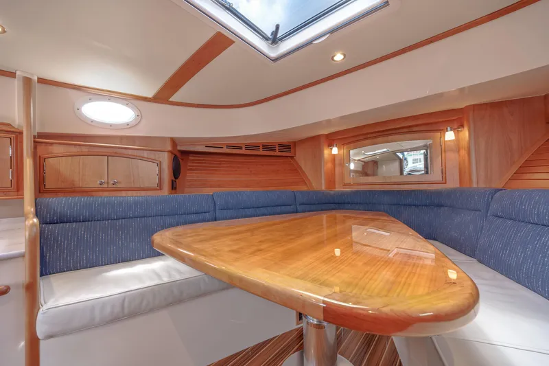 The Do-over Yacht Photos Pics 2024 Hinckley Picnic Boat 40 interior with elegant wood table and blue seating.