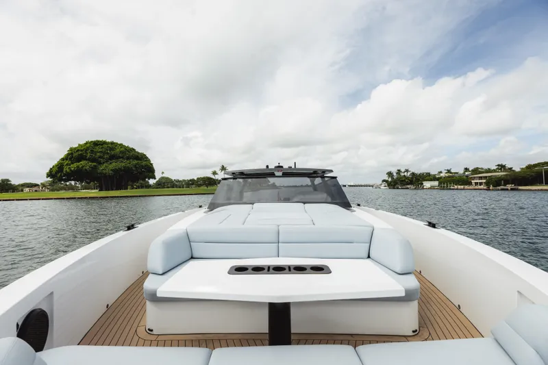 Shir Yacht Photos Pics Luxurious 2024 Vanquish 58 yacht with sleek design on tranquil waterway.
