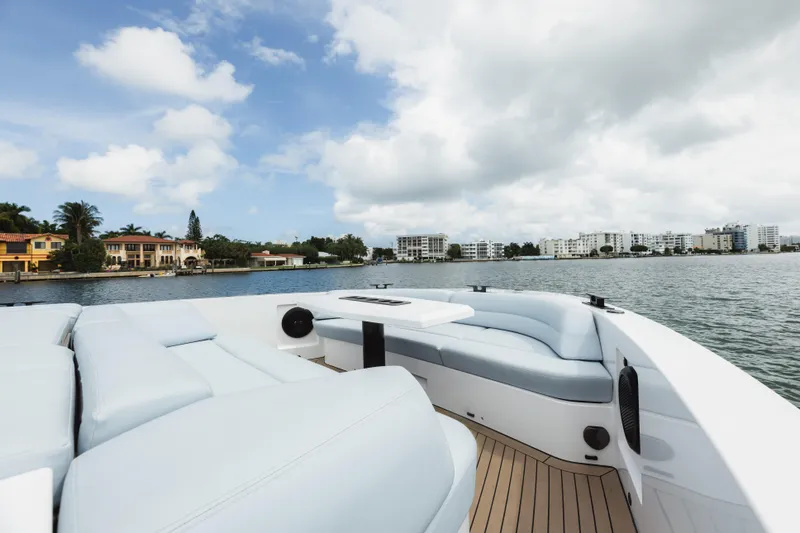 Shir Yacht Photos Pics Luxurious 2024 Vanquish 58 yacht with spacious deck, cruising near waterfront homes.