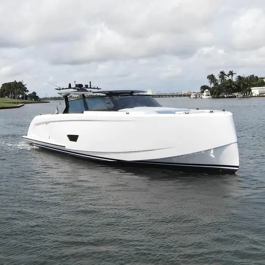 Shir Yacht Photos Pics 2024 Vanquish 58 yacht cruising on a scenic waterway under a cloudy sky.