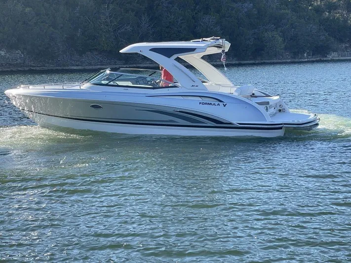Only A Formula Yacht Photos Pics 2025 Formula 310 Bowrider cruising on a serene lake with lush greenery.