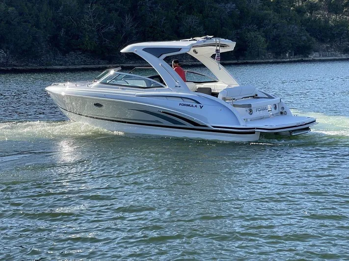 Only A Formula Yacht Photos Pics 2025 Formula 310 Bowrider cruising on a serene lake with lush greenery.