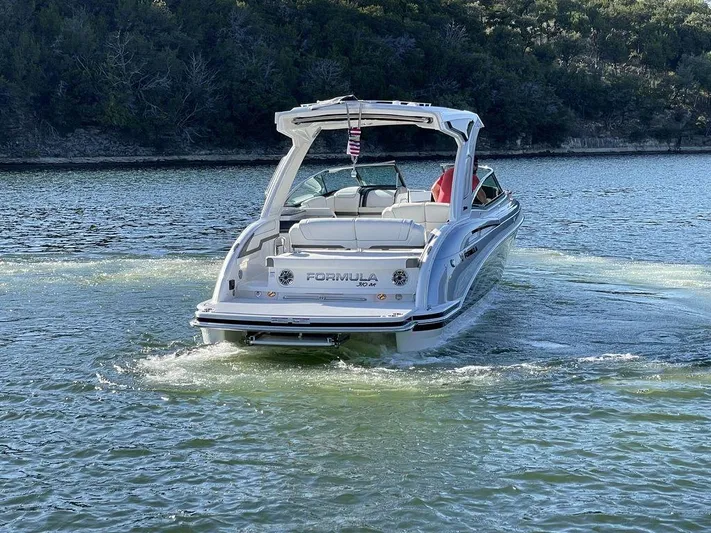 Only A Formula Yacht Photos Pics 2025 Formula 310 Bowrider cruising on a serene lake with lush greenery.
