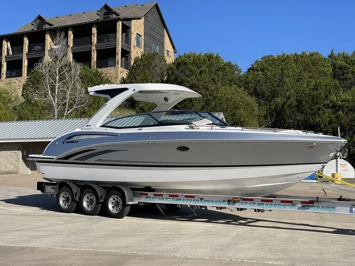 Only A Formula Yacht Photos Pics 2025 Formula 310 Bowrider on trailer, parked outdoors near trees and buildings.