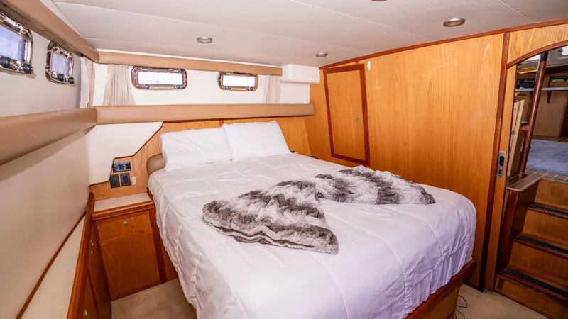 Temptation Yacht Photos Pics Aft cabin bedroom in 2005 Mainship 43 Trawler, featuring cozy bed and wooden interior.