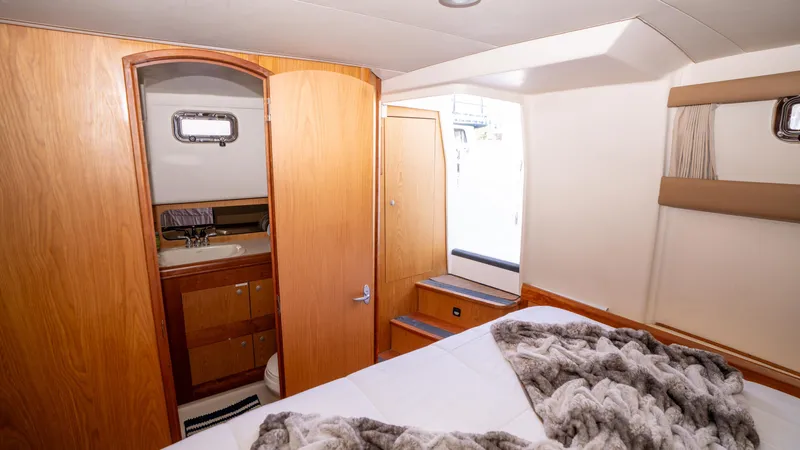 Temptation Yacht Photos Pics 2005 Mainship 43 Trawler Aft Cabin interior with cozy bed and wooden cabinetry.
