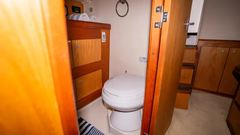 Temptation Yacht Photos Pics 2005 Mainship 43 Trawler Aft Cabin bathroom with wooden cabinetry and modern fixtures.