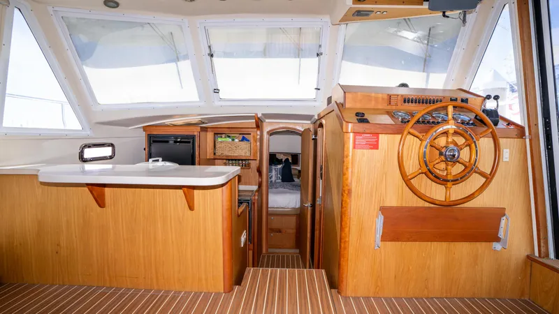 Temptation Yacht Photos Pics 2005 Mainship 43 Trawler Aft Cabin interior with wooden helm and spacious cabin layout.