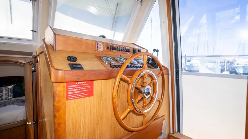 Temptation Yacht Photos Pics 2005 Mainship 43 Trawler Aft Cabin helm with wooden steering wheel and control panel.