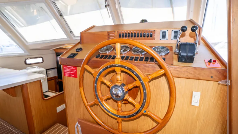 Temptation Yacht Photos Pics 2005 Mainship 43 Trawler Aft Cabin helm with wooden steering wheel and control panel.