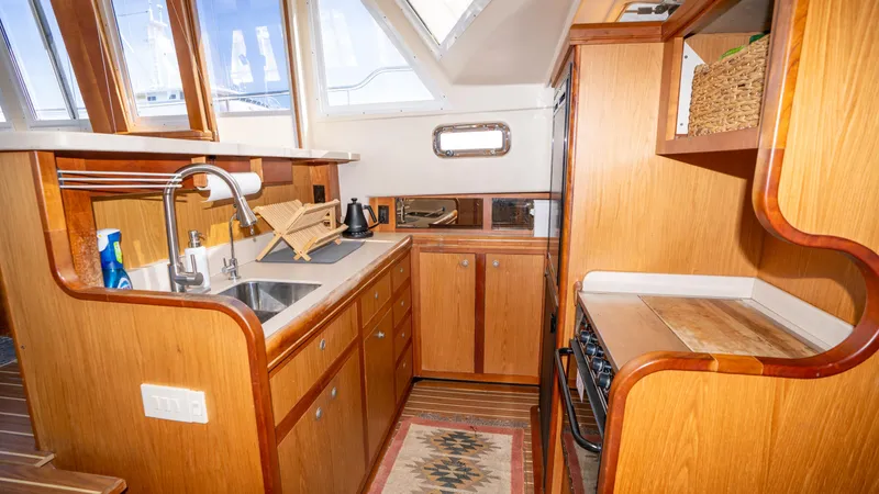 Temptation Yacht Photos Pics 2005 Mainship 43 Trawler Aft Cabin kitchen with wood cabinetry and modern appliances.