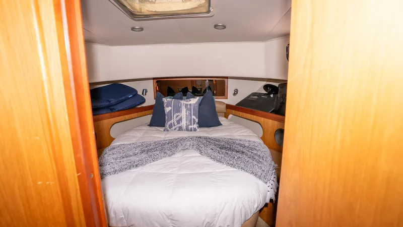 Temptation Yacht Photos Pics 2005 Mainship 43 Trawler Aft Cabin bedroom with cozy bedding and wooden accents.