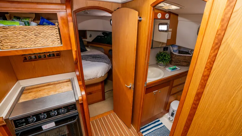 Temptation Yacht Photos Pics 2005 Mainship 43 Trawler Aft Cabin interior with kitchen, bathroom, and cozy bedroom.